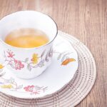 Tazza di tè Regene Tea con foglie di tè e limone, simbolo di benessere e recensioni positive.