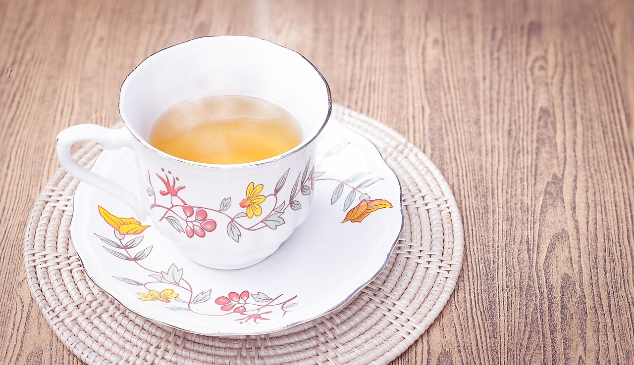 Tazza di tè Regene Tea con foglie di tè e limone, simbolo di benessere e recensioni positive.